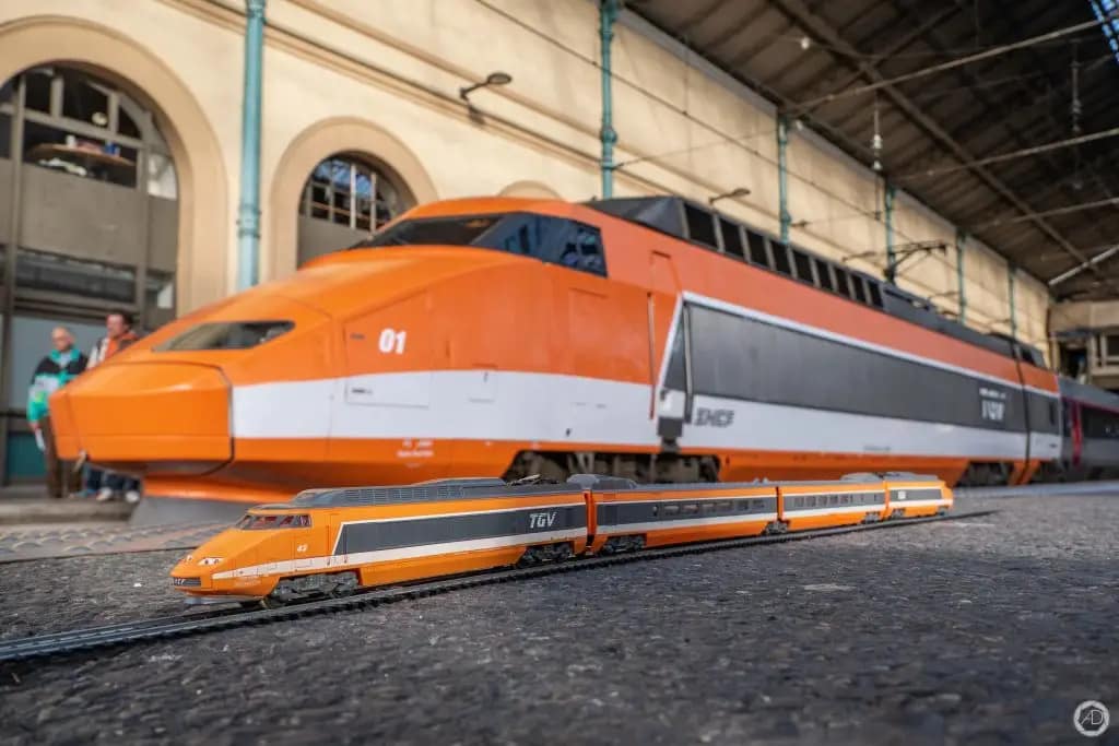 La rame 01 Patrick est prise en photo avec au premier plan une rame TGV Sud Est miniature